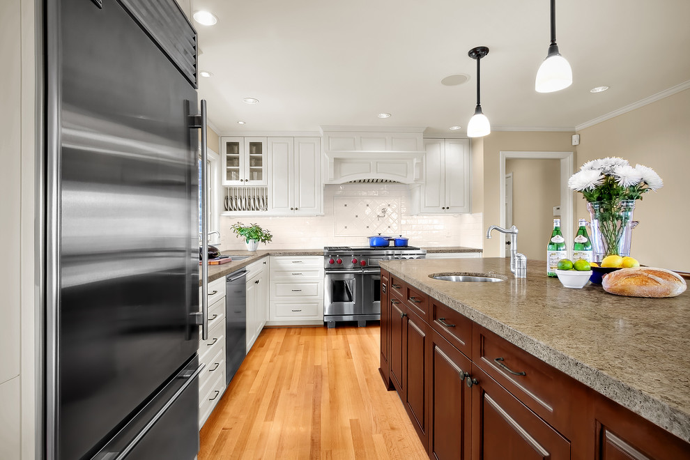 Klassische Küche in L-Form mit Granit-Arbeitsplatte, Küchengeräten aus Edelstahl und Küchenrückwand in Weiß in Seattle