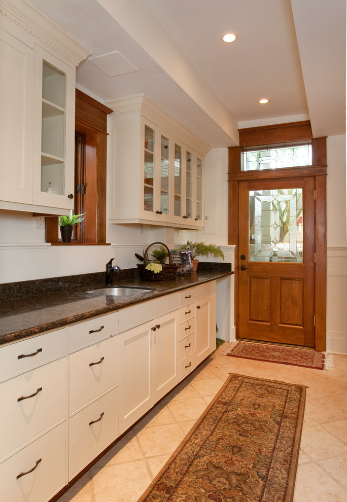 Example of a small ornate single-wall ceramic tile and beige floor enclosed kitchen design in Los Angeles with an undermount sink, flat-panel cabinets, white cabinets, granite countertops and no island