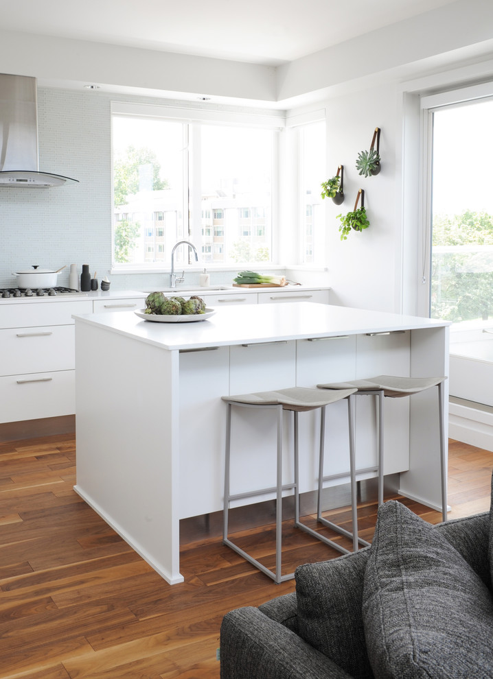 Mid-sized trendy l-shaped open concept kitchen photo in Vancouver with flat-panel cabinets, white cabinets, quartz countertops, glass tile backsplash and an island