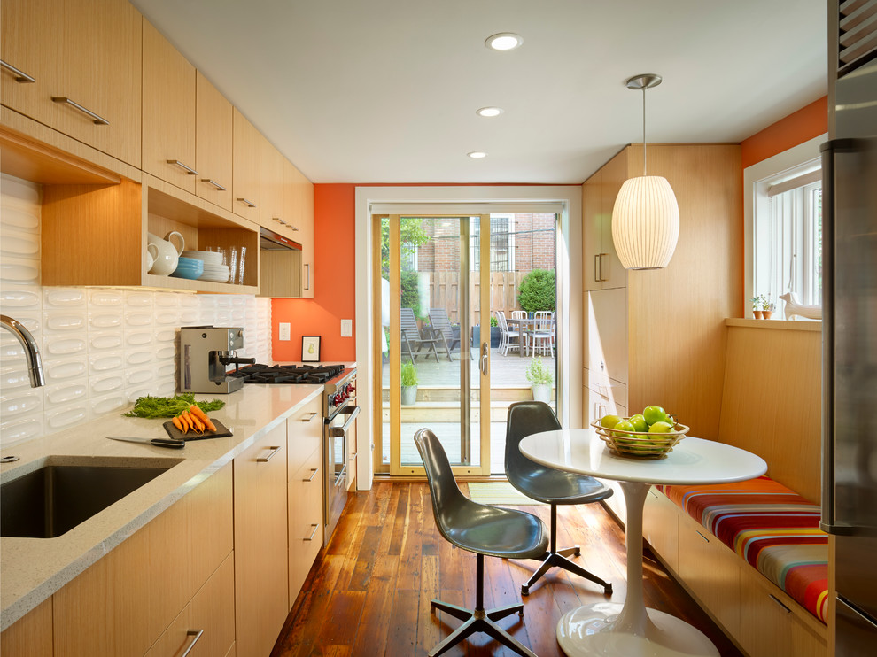 Geschlossene Moderne Küche mit Küchengeräten aus Edelstahl, Unterbauwaschbecken, flächenbündigen Schrankfronten, hellen Holzschränken und Küchenrückwand in Weiß in Philadelphia