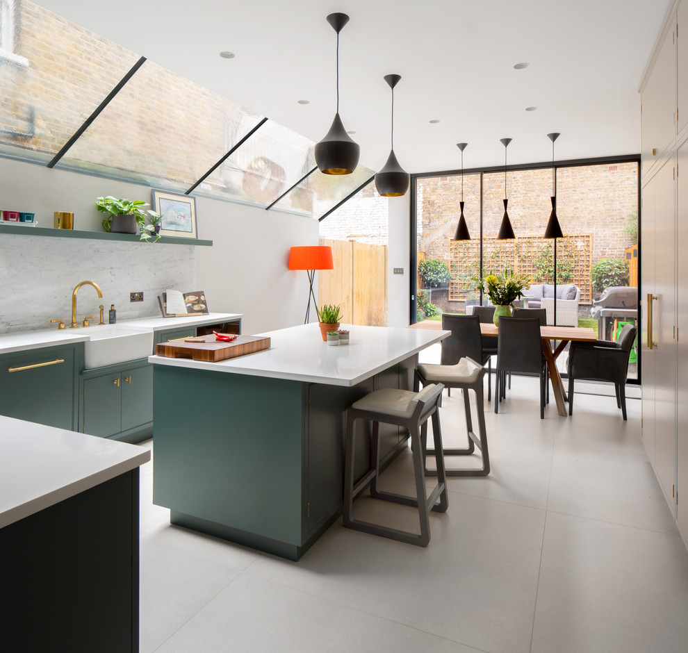 ロンドンにある広いコンテンポラリースタイルのおしゃれなキッチン (エプロンフロントシンク、緑のキャビネット、珪岩カウンター、マルチカラーのキッチンパネル、大理石のキッチンパネル、シルバーの調理設備、磁器タイルの床、グレーの床、白いキッチンカウンター) の写真
