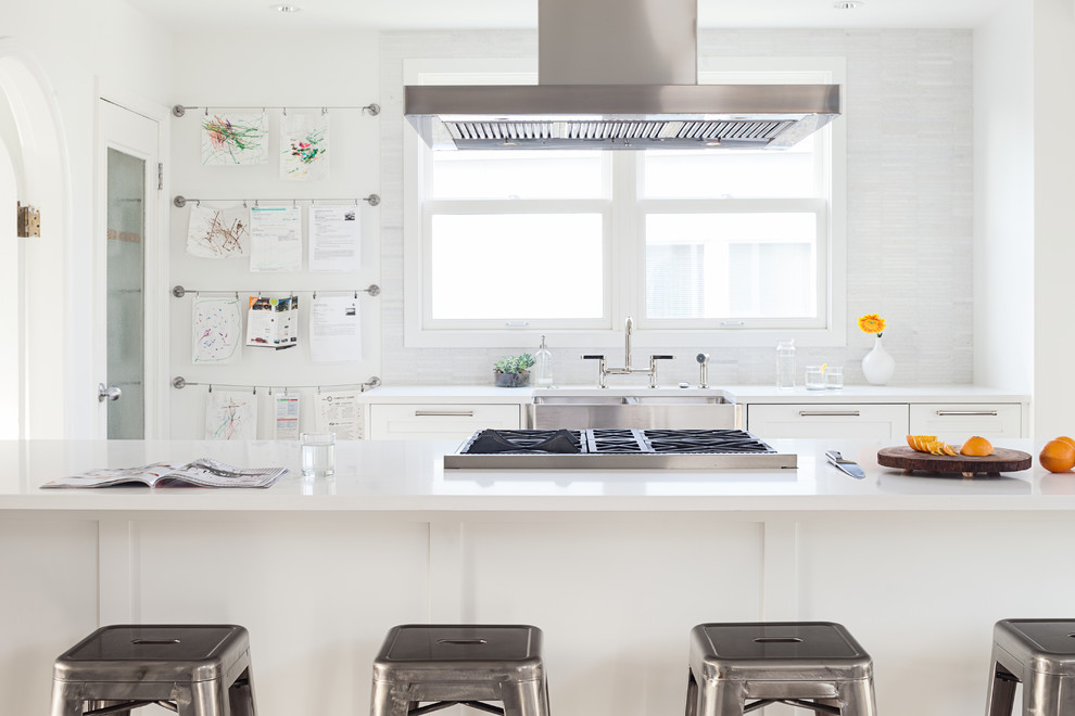 Photo of a traditional galley kitchen in Vancouver with a belfast sink, flat-panel cabinets, white cabinets, white splashback and matchstick tiled splashback.