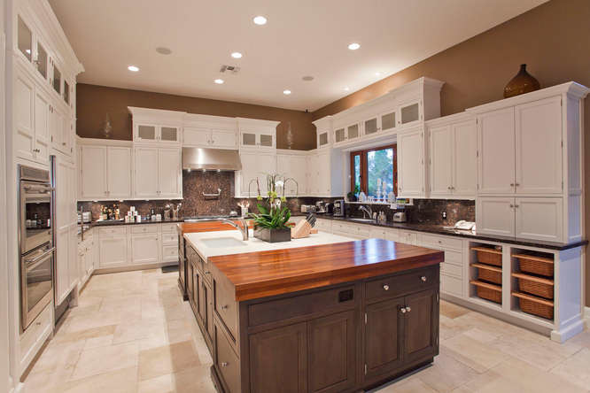 Enclosed kitchen - large traditional u-shaped enclosed kitchen idea in Las Vegas with flat-panel cabinets, white cabinets, wood countertops, stainless steel appliances and an island