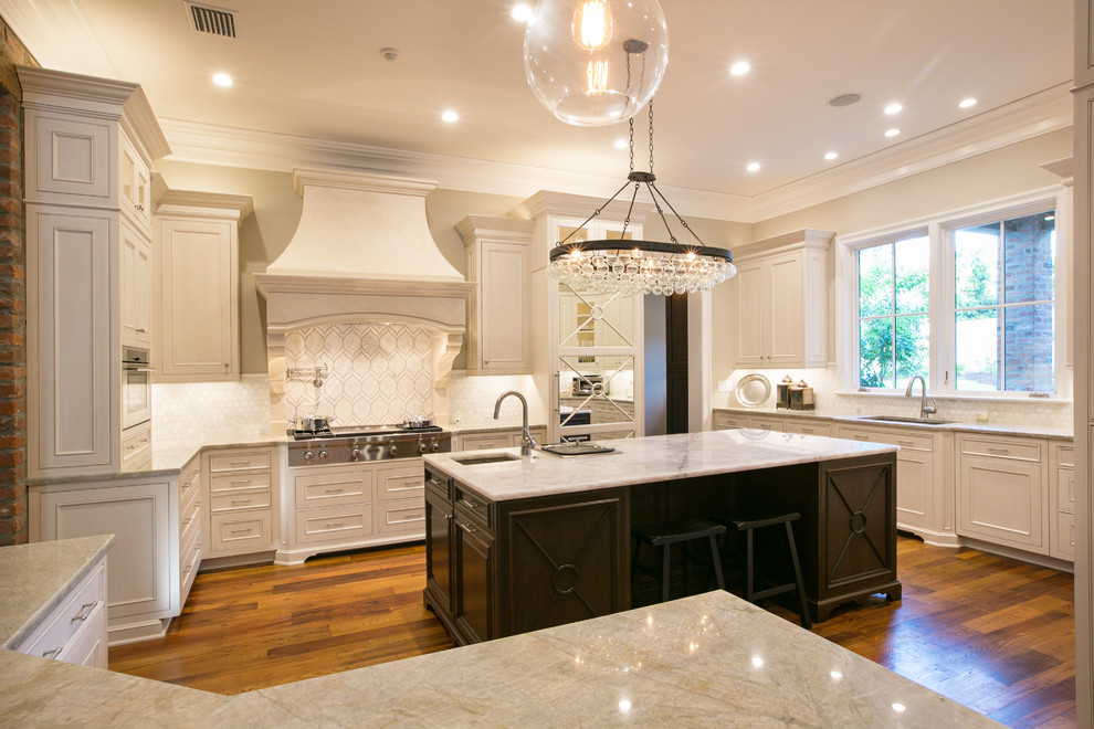 Example of a large transitional u-shaped dark wood floor kitchen design in New Orleans with an undermount sink, beaded inset cabinets, white cabinets, quartzite countertops, white backsplash, mosaic tile backsplash, stainless steel appliances and two islands