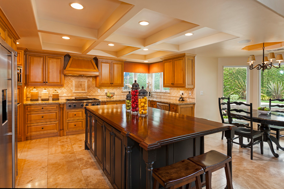Klassische Wohnküche in U-Form mit profilierten Schrankfronten, hellbraunen Holzschränken, Küchenrückwand in Beige und Küchengeräten aus Edelstahl in Orange County