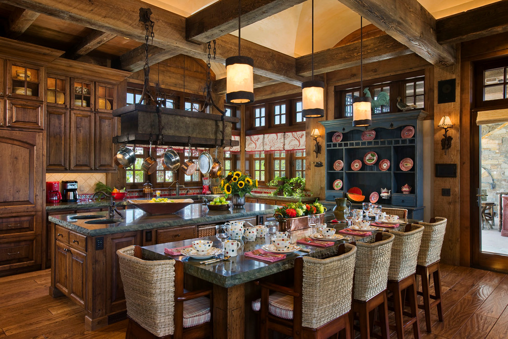 Rustic l-shaped kitchen/diner in Other with raised-panel cabinets and dark wood cabinets.