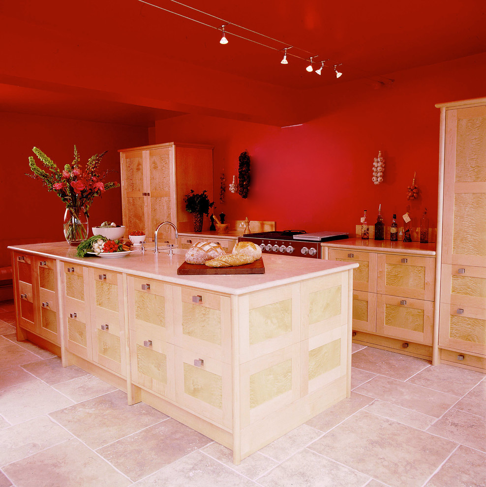 Modern inredning av ett kök och matrum, med en dubbel diskho, luckor med infälld panel, bänkskiva i kalksten, integrerade vitvaror, kalkstensgolv och en köksö