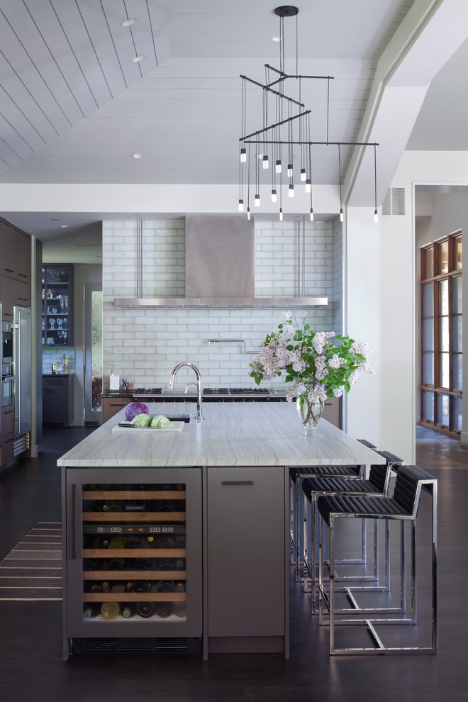 Inspiration for a large contemporary dark wood floor and brown floor kitchen remodel in Denver with an undermount sink, flat-panel cabinets, gray cabinets, quartzite countertops, white backsplash, an island, white countertops, subway tile backsplash and stainless steel appliances