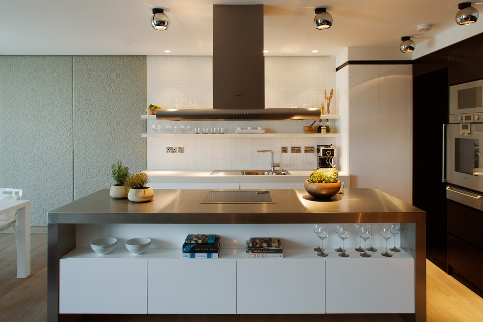 Kitchen - mid-sized contemporary l-shaped light wood floor and beige floor kitchen idea in London with a double-bowl sink, flat-panel cabinets, white backsplash, mosaic tile backsplash, stainless steel appliances and an island