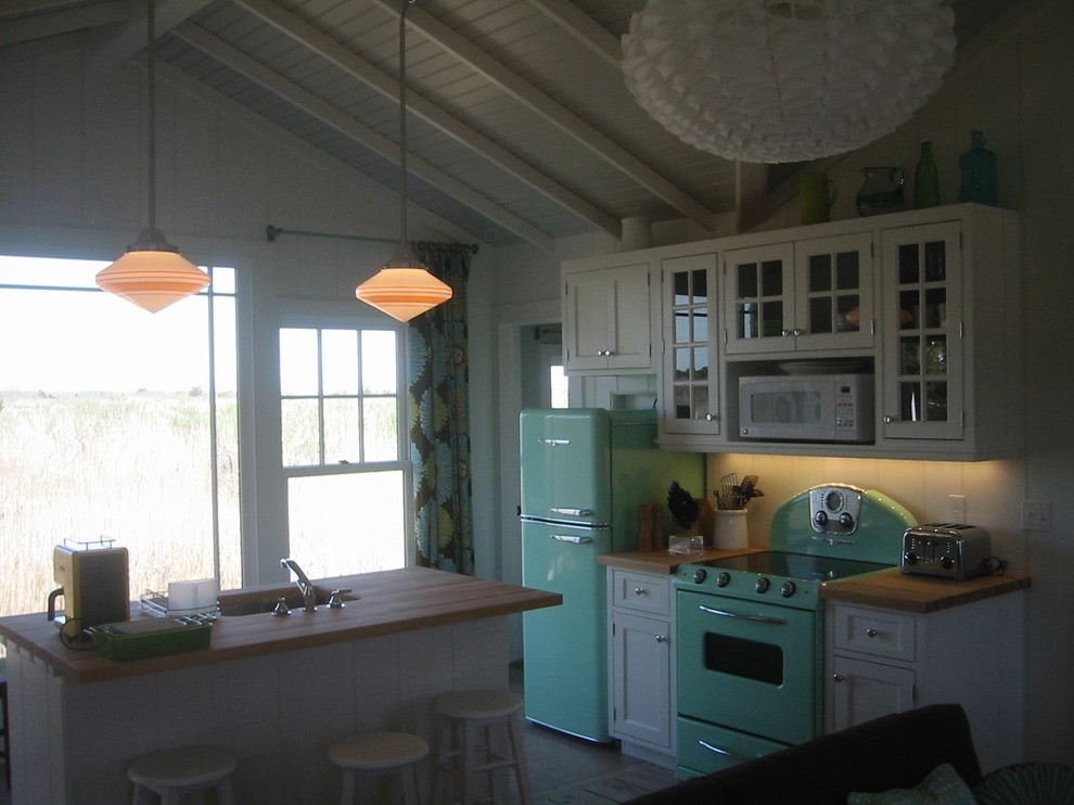 Immagine di una cucina american style con lavello sottopiano, ante con riquadro incassato, ante bianche, top in legno e elettrodomestici colorati