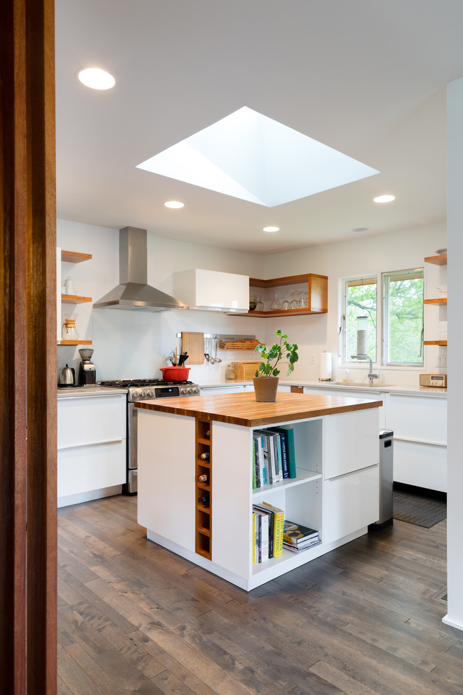 Photo of a medium sized midcentury l-shaped open plan kitchen in Omaha with a double-bowl sink, flat-panel cabinets, white cabinets, laminate countertops, white splashback, stainless steel appliances, dark hardwood flooring, multiple islands and black floors.