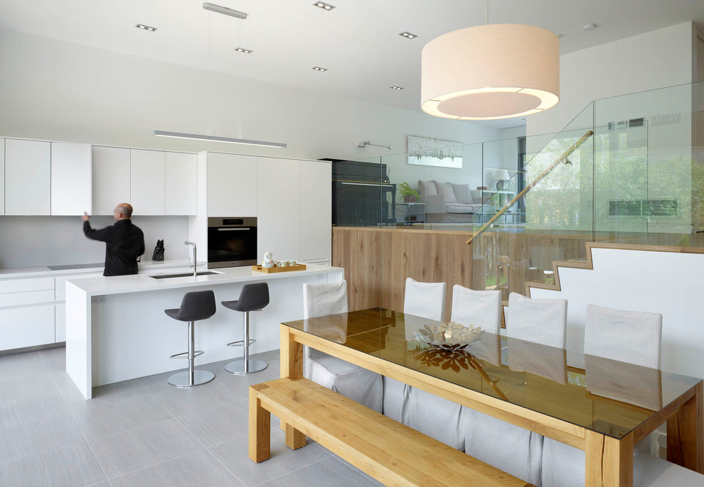 Foto de cocina comedor contemporánea con fregadero bajoencimera, armarios con paneles lisos, puertas de armario blancas y electrodomésticos de acero inoxidable