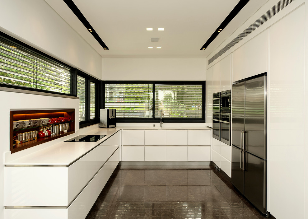 Пример оригинального дизайна: отдельная, п-образная кухня в стиле модернизм с плоскими фасадами, техникой из нержавеющей стали и черно-белыми фасадами