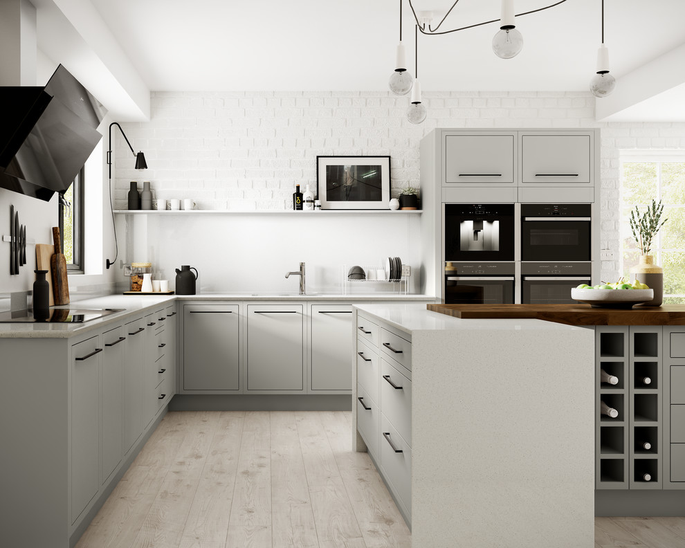 Photo of a medium sized contemporary l-shaped enclosed kitchen in Other with flat-panel cabinets, grey cabinets, white splashback, glass sheet splashback, integrated appliances, laminate floors and an island.