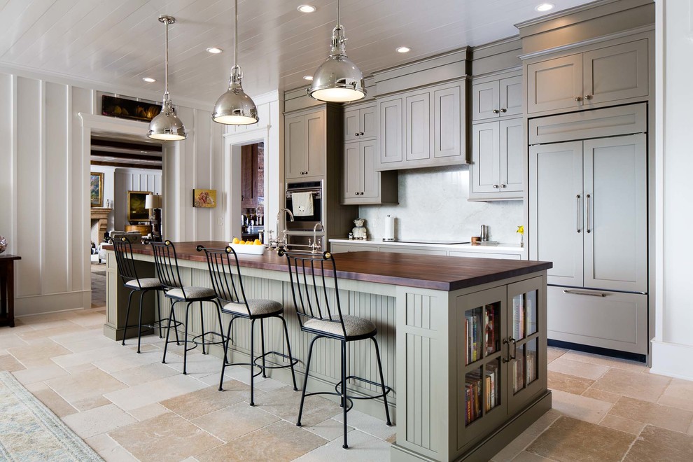 Example of a mid-sized transitional single-wall slate floor eat-in kitchen design in Nashville with a farmhouse sink, flat-panel cabinets, green cabinets, wood countertops, white backsplash, paneled appliances and an island