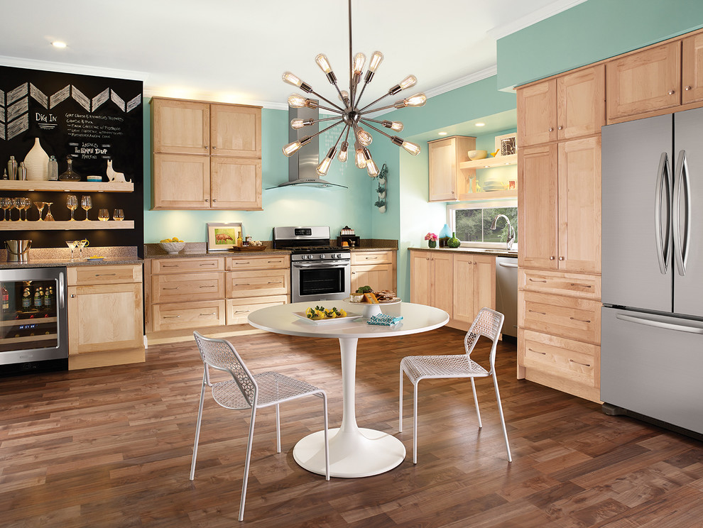 Eklektische Wohnküche ohne Insel in L-Form mit Unterbauwaschbecken, Schrankfronten im Shaker-Stil, hellen Holzschränken, Küchengeräten aus Edelstahl und braunem Holzboden in Detroit