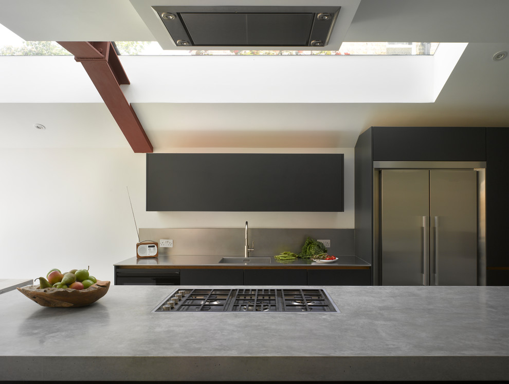 Design ideas for a large contemporary single-wall kitchen/diner in London with flat-panel cabinets, black cabinets, concrete worktops, an island, grey floors and beige worktops.