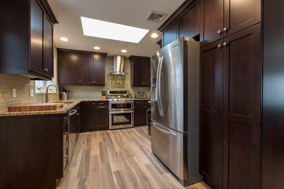Example of a small transitional l-shaped porcelain tile eat-in kitchen design in Bridgeport with an undermount sink, shaker cabinets, dark wood cabinets, granite countertops, beige backsplash, glass tile backsplash, stainless steel appliances and no island
