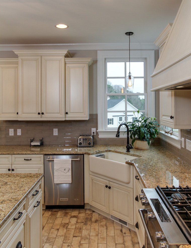 Exempel på ett stort lantligt kök, med en rustik diskho, skåp i shakerstil, beige skåp, granitbänkskiva, grått stänkskydd, stänkskydd i keramik, rostfria vitvaror, tegelgolv, en köksö och vitt golv