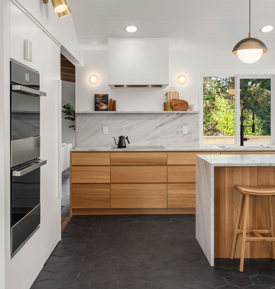 Mid-Century Küche mit flächenbündigen Schrankfronten, hellen Holzschränken, Marmor-Arbeitsplatte, Rückwand aus Marmor, Terrakottaboden, Kücheninsel, schwarzem Boden und gewölbter Decke in Portland