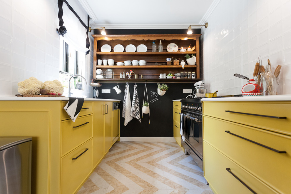 テルアビブにある中くらいなトラディショナルスタイルのおしゃれなII型キッチン (黄色いキャビネット、白いキッチンパネル、黒い調理設備) の写真