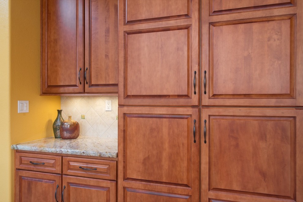 Example of a classic u-shaped eat-in kitchen design in San Diego with a double-bowl sink, raised-panel cabinets, medium tone wood cabinets, granite countertops, multicolored backsplash and stainless steel appliances