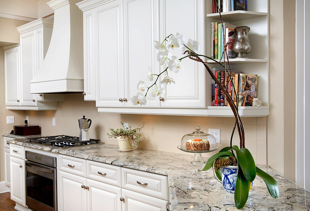 Elegant kitchen photo in Tampa with granite countertops, white cabinets and beige backsplash