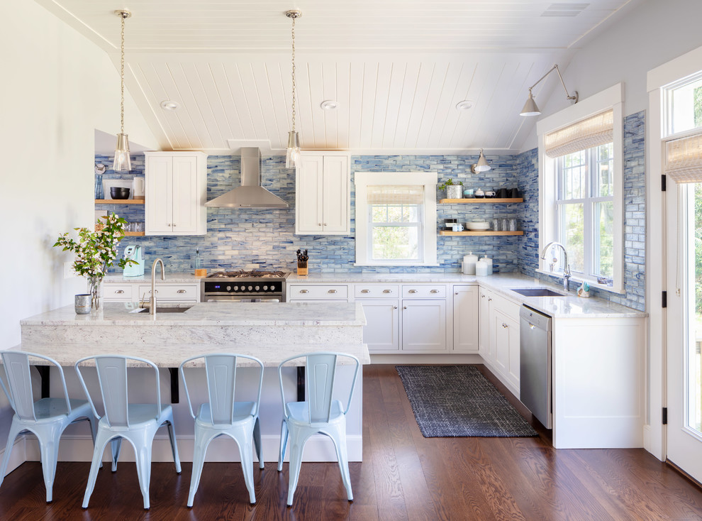 Design ideas for a coastal l-shaped kitchen in Providence with a submerged sink, shaker cabinets, white cabinets, blue splashback, stainless steel appliances, medium hardwood flooring, a breakfast bar and white worktops.