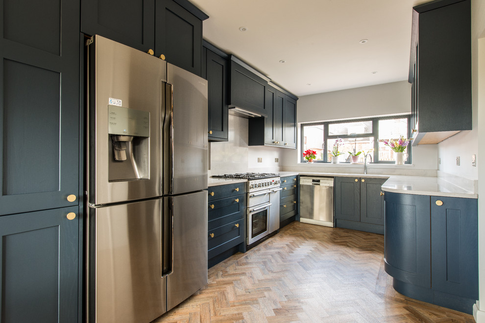 Medium sized classic u-shaped kitchen in Kent with recessed-panel cabinets, blue cabinets, quartz worktops, light hardwood flooring, no island, beige floors and white worktops.