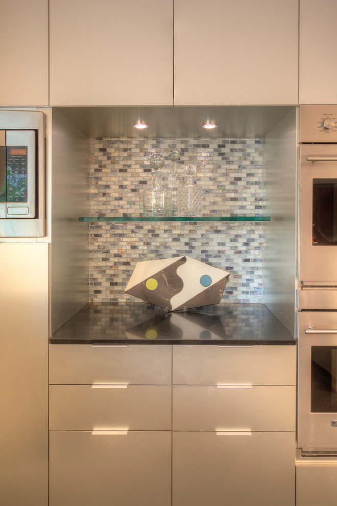 Foto de cocina moderna con armarios con paneles lisos, puertas de armario en acero inoxidable, encimera de cuarzo compacto, salpicadero multicolor y salpicadero de azulejos de vidrio
