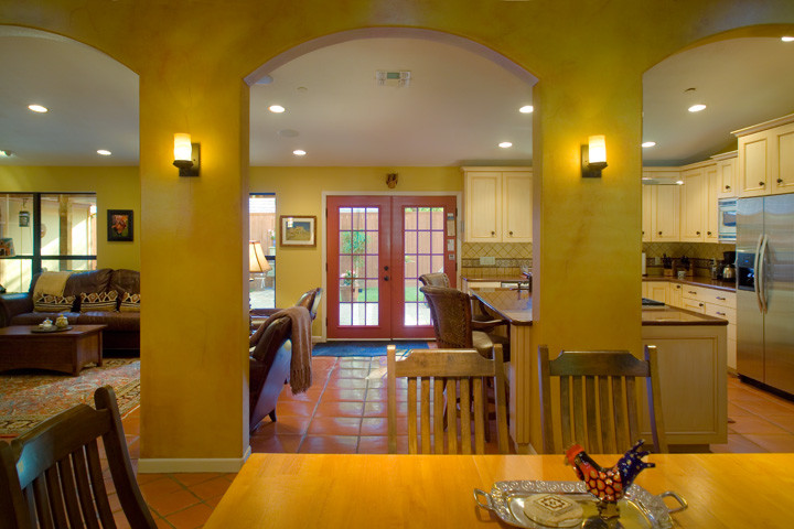 Bild på ett stort rustikt kök, med en dubbel diskho, luckor med infälld panel, skåp i ljust trä, granitbänkskiva, beige stänkskydd, stänkskydd i stenkakel, rostfria vitvaror, klinkergolv i terrakotta och en köksö