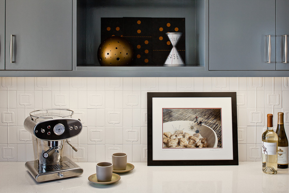 На фото: кухня в стиле модернизм с плоскими фасадами, серыми фасадами, столешницей из кварцевого агломерата, белым фартуком и фартуком из керамогранитной плитки с