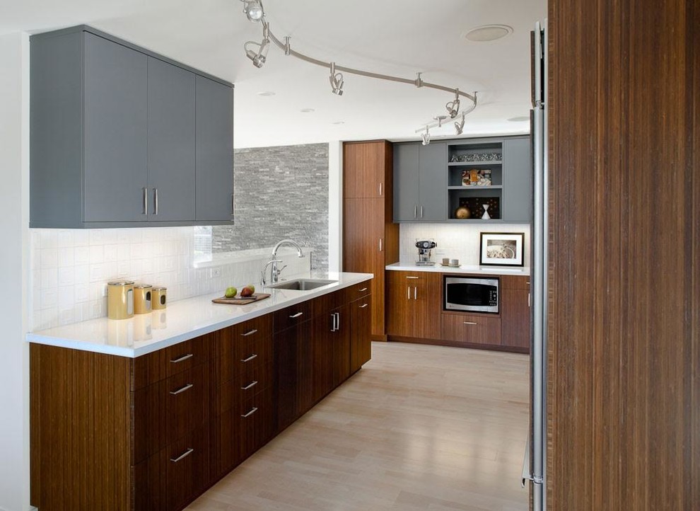 サンフランシスコにあるコンテンポラリースタイルのおしゃれなキッチン (フラットパネル扉のキャビネット、グレーのキャビネット、アンダーカウンターシンク、白いキッチンパネル、磁器タイルのキッチンパネル、淡色無垢フローリング) の写真