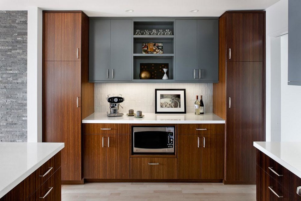 Diseño de cocina moderna con armarios con paneles lisos, puertas de armario de madera en tonos medios y salpicadero blanco