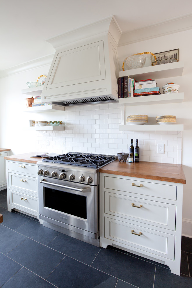 Inspiration för ett avskilt, stort vintage u-kök, med luckor med infälld panel, vita skåp, träbänkskiva, vitt stänkskydd och en köksö