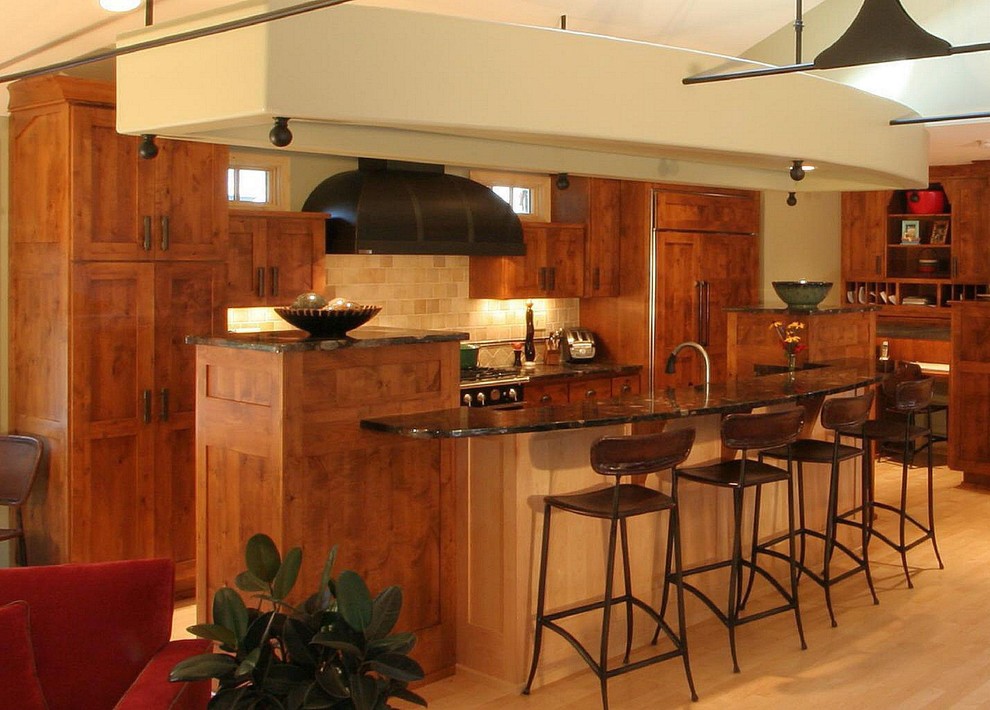 Стильный дизайн: кухня в классическом стиле с обеденным столом, врезной мойкой, плоскими фасадами, фасадами цвета дерева среднего тона, гранитной столешницей, бежевым фартуком, фартуком из керамогранитной плитки и черной техникой - последний тренд