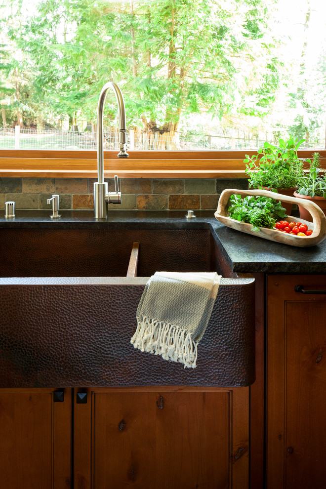 Inspiration for a mid-sized country l-shaped porcelain tile and gray floor enclosed kitchen remodel in Seattle with a farmhouse sink, shaker cabinets, medium tone wood cabinets, granite countertops, gray backsplash, slate backsplash, stainless steel appliances and an island