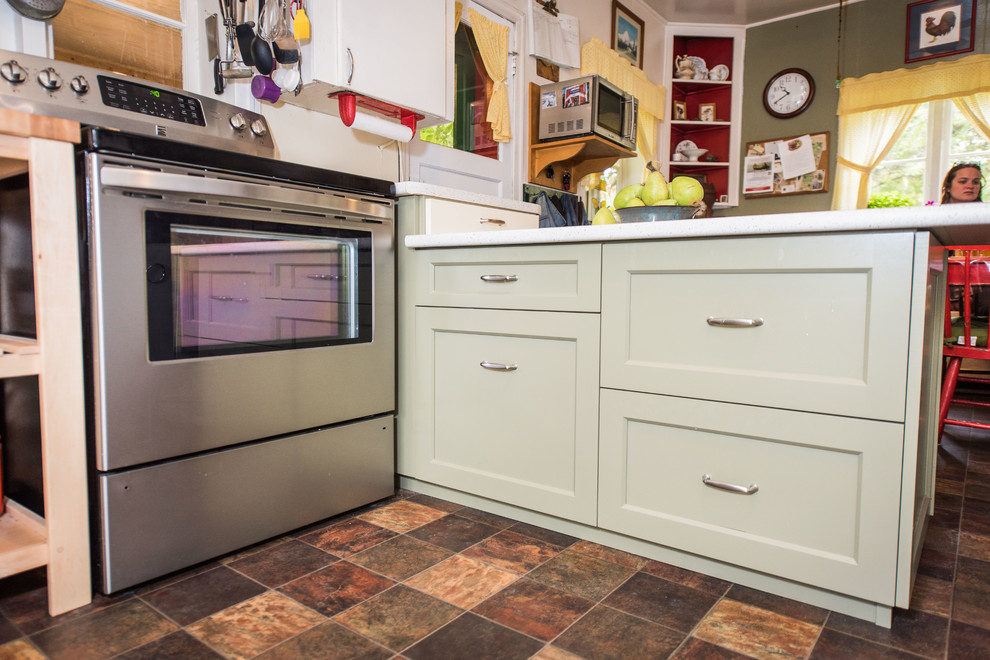 This is an example of a small country u-shaped kitchen in Other with a built-in sink, shaker cabinets, green cabinets, laminate countertops, stainless steel appliances, lino flooring, a breakfast bar, brown floors and white worktops.