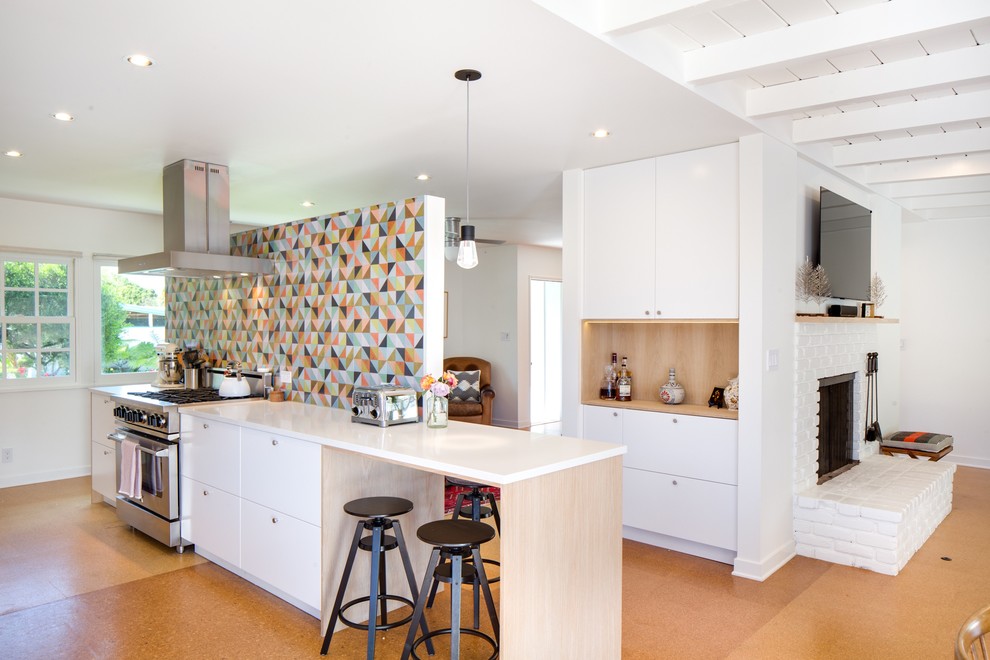 Foto di una cucina moderna con ante lisce, ante bianche, top in quarzo composito, paraspruzzi multicolore, paraspruzzi con piastrelle di cemento, elettrodomestici in acciaio inossidabile e pavimento marrone