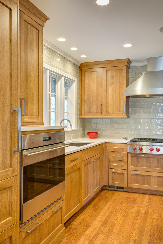 Mid-sized arts and crafts l-shaped light wood floor eat-in kitchen photo in Kansas City with an undermount sink, shaker cabinets, light wood cabinets, quartz countertops, gray backsplash, subway tile backsplash, stainless steel appliances and an island