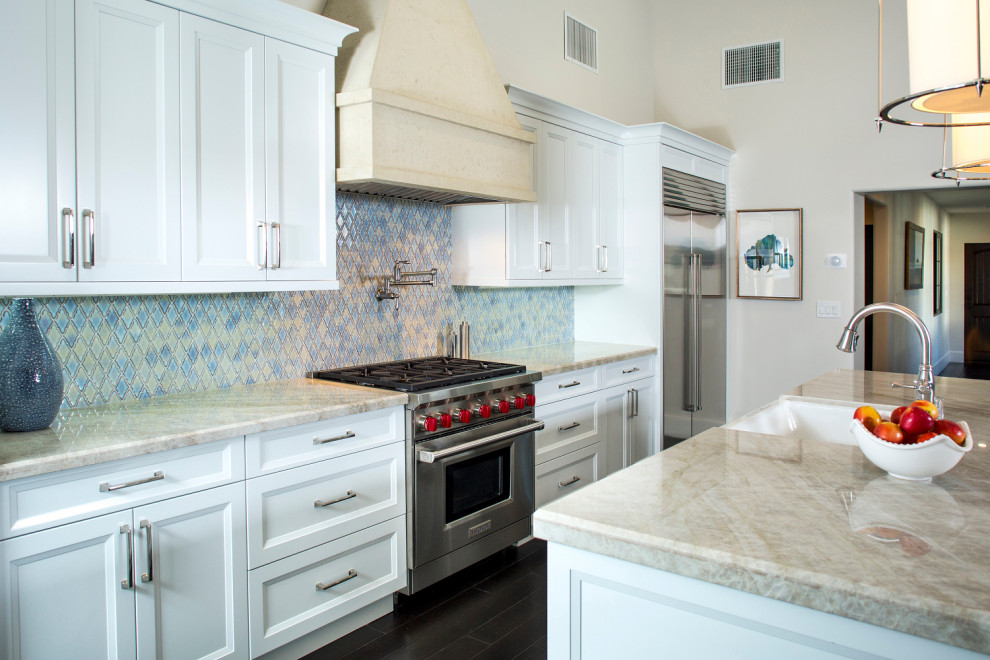ラスベガスにある高級な広いエクレクティックスタイルのおしゃれなキッチン (シングルシンク、ガラス扉のキャビネット、白いキャビネット、珪岩カウンター、青いキッチンパネル、モザイクタイルのキッチンパネル、シルバーの調理設備、濃色無垢フローリング、茶色い床、ベージュのキッチンカウンター) の写真