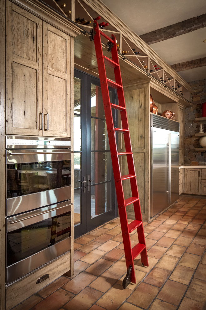 Cette image montre une cuisine chalet avec un placard avec porte à panneau encastré et un électroménager en acier inoxydable.