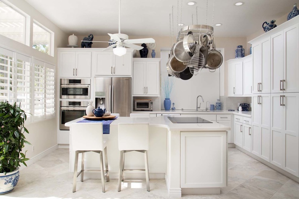 Mid-sized trendy l-shaped porcelain tile kitchen photo in San Diego with an undermount sink, shaker cabinets, white cabinets, quartz countertops, white backsplash, subway tile backsplash, stainless steel appliances and an island