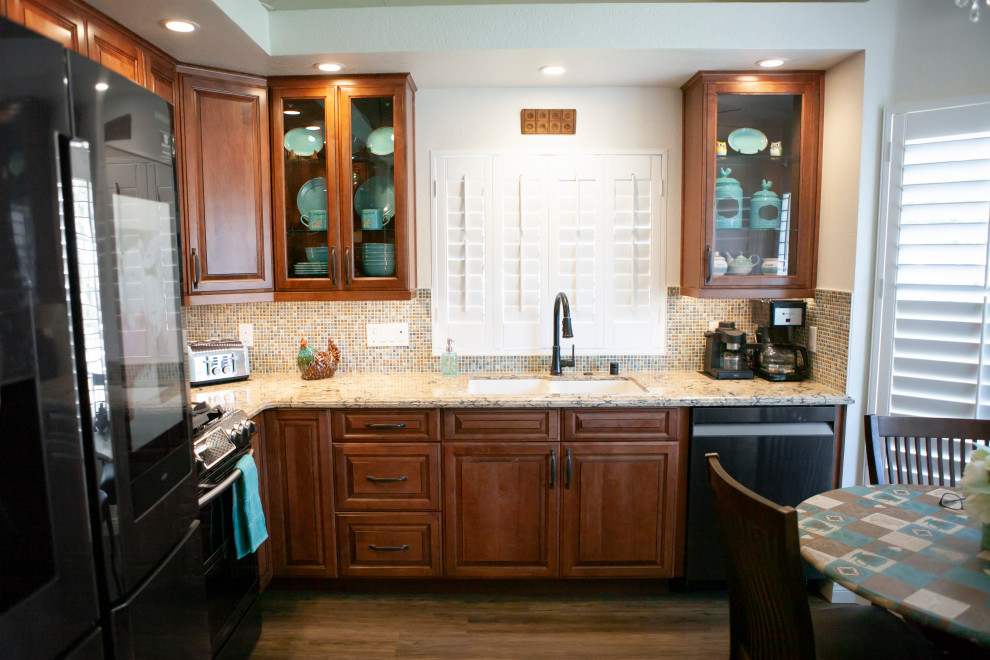 Mid-sized elegant l-shaped laminate floor and coffered ceiling eat-in kitchen photo in Los Angeles with a double-bowl sink, raised-panel cabinets, medium tone wood cabinets, quartz countertops, multicolored backsplash, glass tile backsplash, black appliances, no island and brown countertops