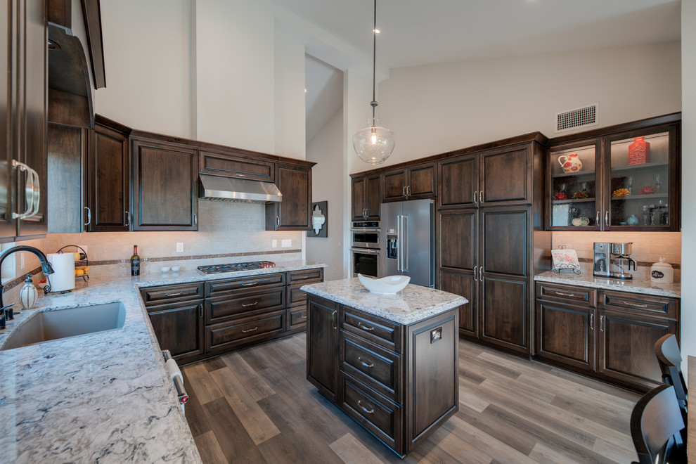 Eat-in kitchen - large transitional u-shaped eat-in kitchen idea in San Diego with an undermount sink, raised-panel cabinets, dark wood cabinets, granite countertops, beige backsplash, porcelain backsplash, stainless steel appliances, an island and multicolored countertops