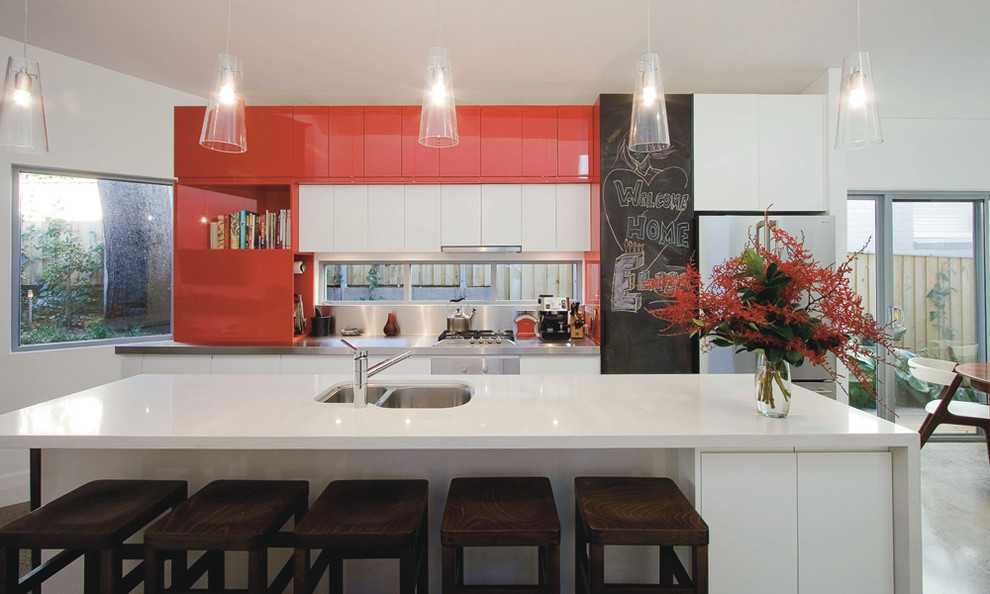 Foto de cocina contemporánea con fregadero de doble seno, armarios con paneles lisos, puertas de armario rojas y electrodomésticos blancos