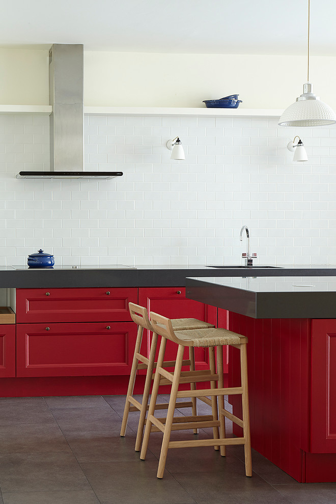 Пример оригинального дизайна: кухня в стиле неоклассика (современная классика) с фасадами с утопленной филенкой, красными фасадами, белым фартуком, фартуком из плитки кабанчик, техникой из нержавеющей стали и островом
