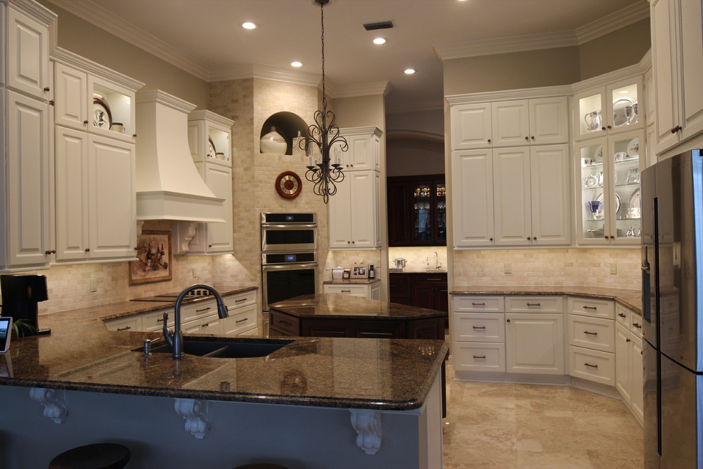 Enclosed kitchen - large traditional u-shaped porcelain tile and beige floor enclosed kitchen idea in Jacksonville with white cabinets, an island, a double-bowl sink, raised-panel cabinets, granite countertops, beige backsplash, porcelain backsplash, stainless steel appliances and multicolored countertops
