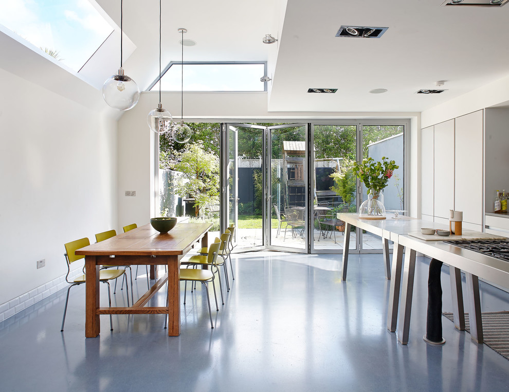 Große Moderne Wohnküche mit flächenbündigen Schrankfronten, weißen Schränken, Edelstahl-Arbeitsplatte, Linoleum, Kücheninsel und grauem Boden in Dublin