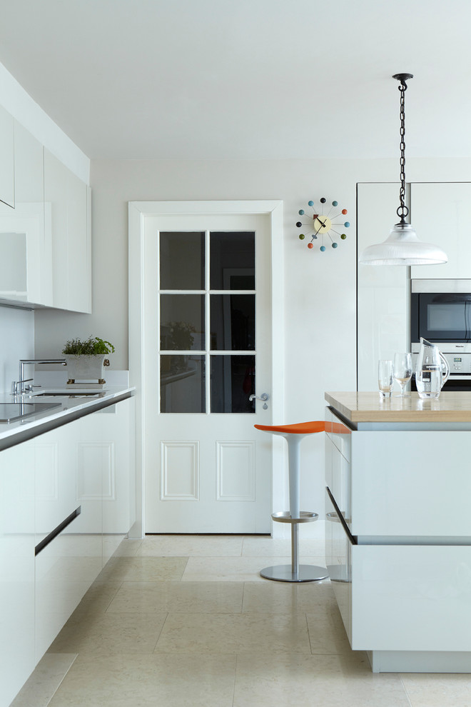 Moderne Küche mit flächenbündigen Schrankfronten und weißen Schränken in Dublin